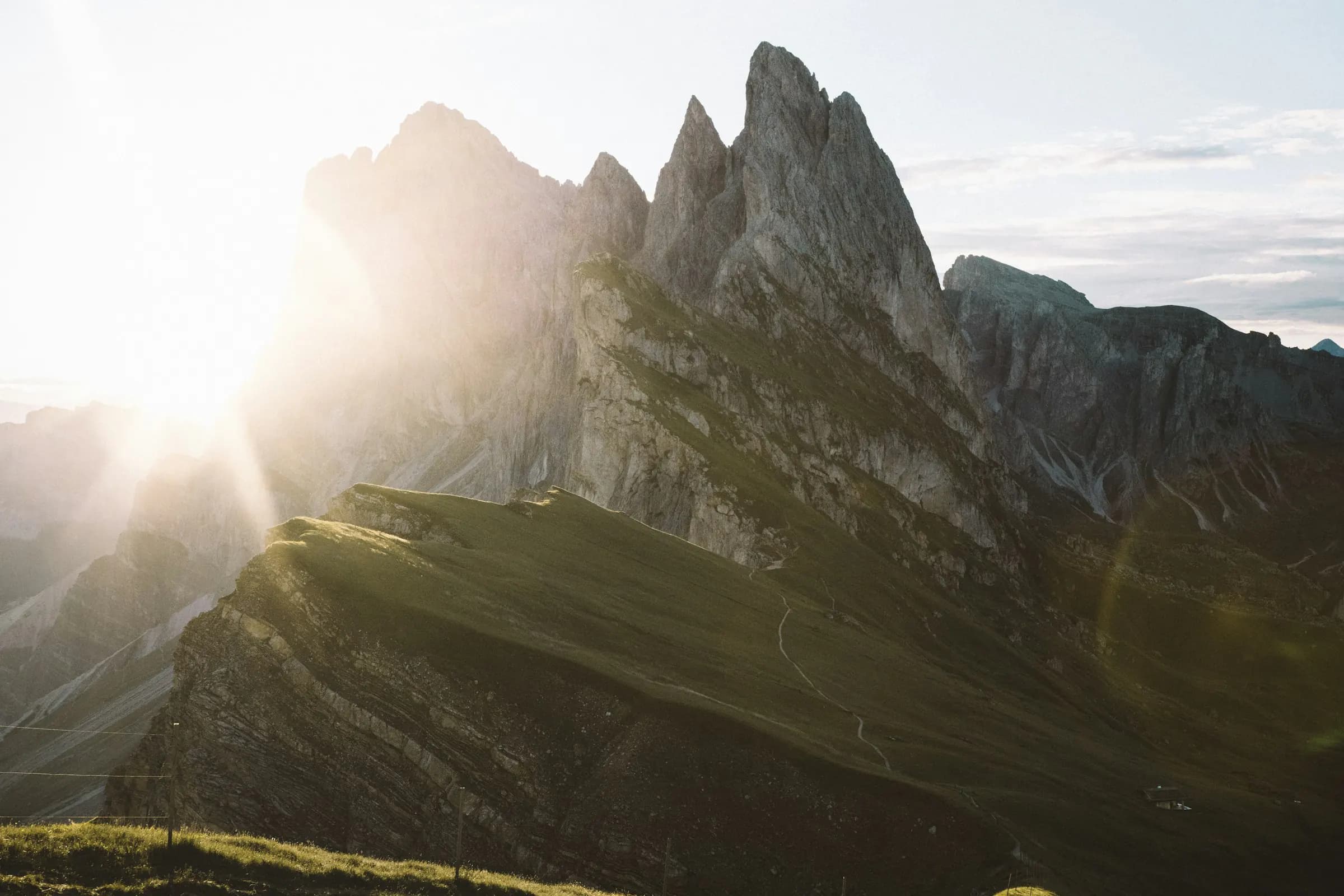 Sunrise behind the sharp mountain ridge at Seceda in the Dolomites
