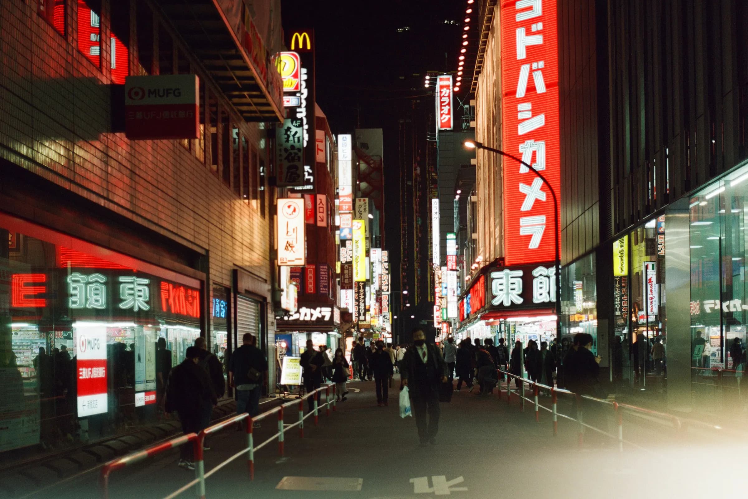 A busy Tokyo street with bright signs at night