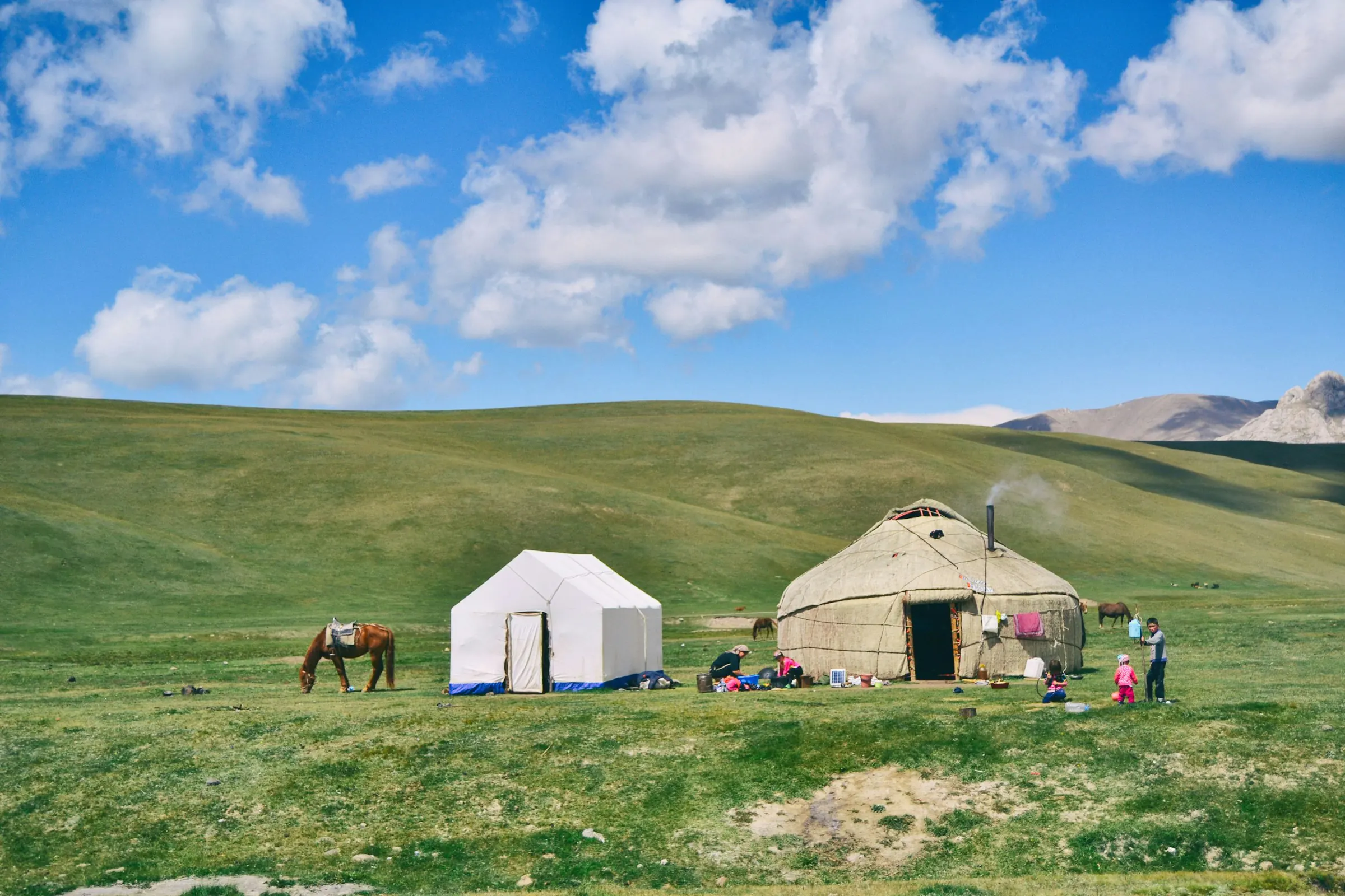 A yurt, horses and a family on the grassland at Song-Kul