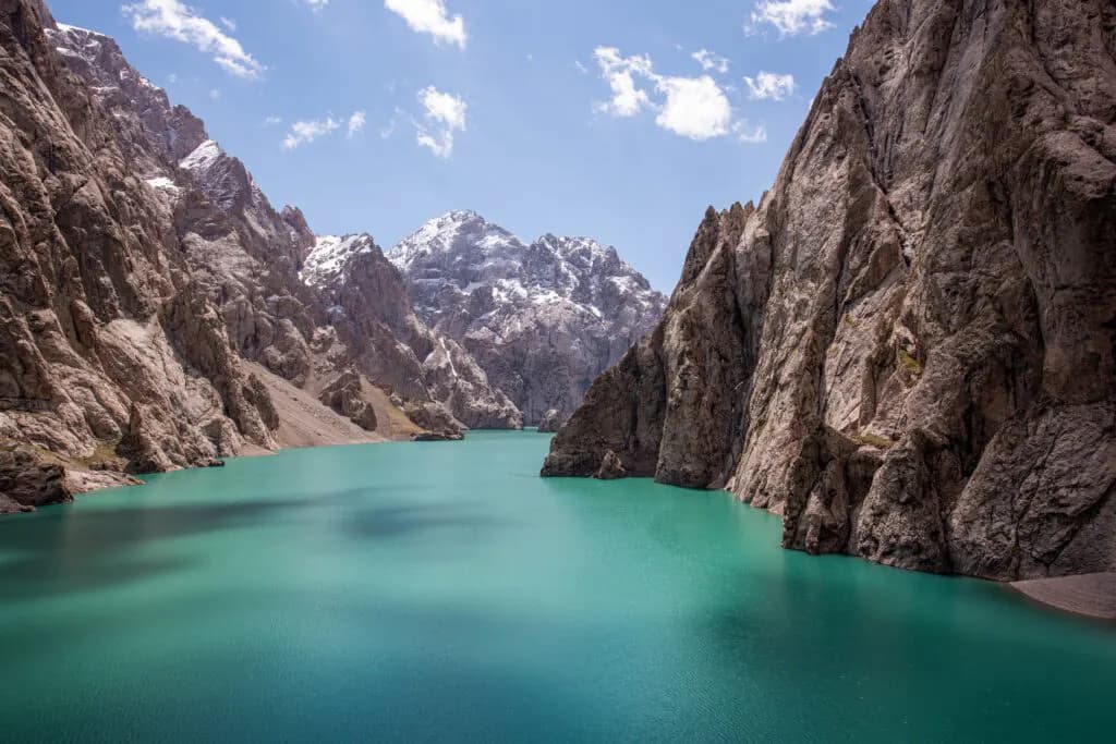 Turquoise water and steep cliffs at Kel-Suu Lake