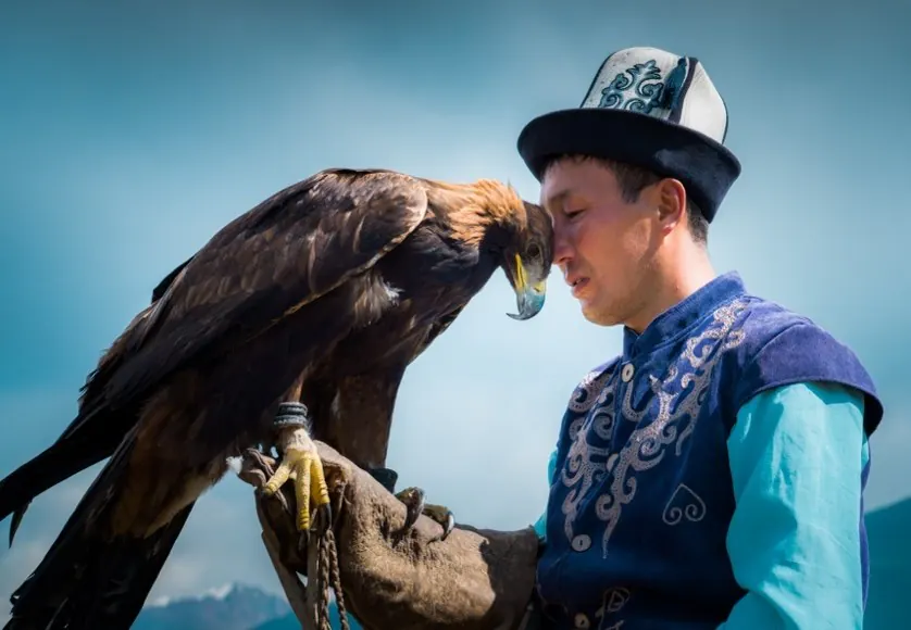 A Kyrgyz eagle hunter holding a golden eagle