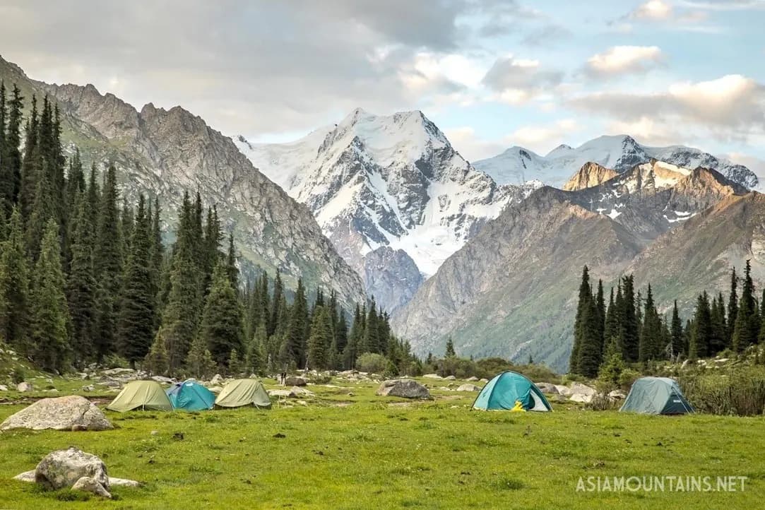 Tents below snow-covered peaks in Karakol Gorge